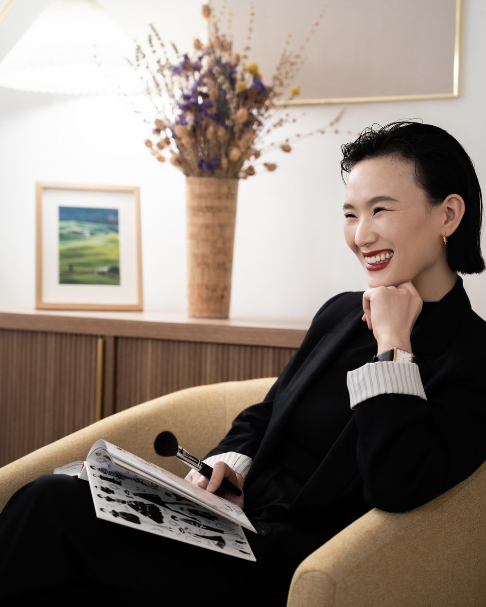 Luna Luo, founder of Celadon Luxe, smiling in her makeup studio