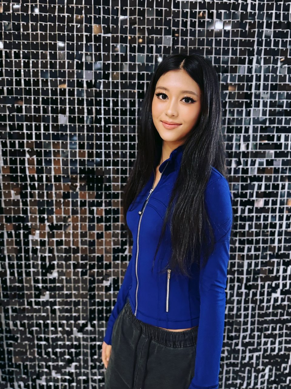 Party makeup in front of a sequin wall